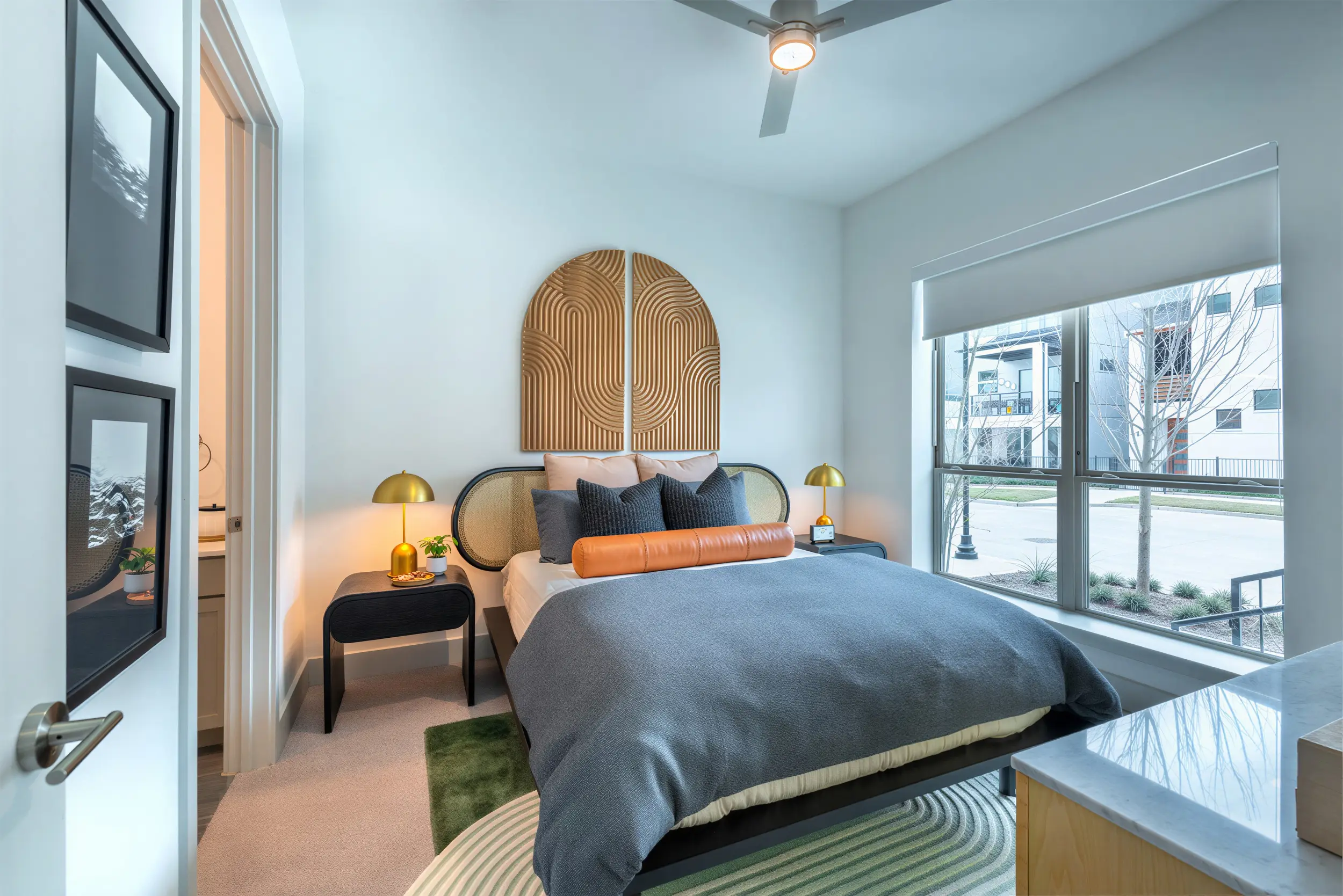 Bright apartment bedroom with ceiling fan and large windows at The View at Sapphire Bay in Rowlett, TX